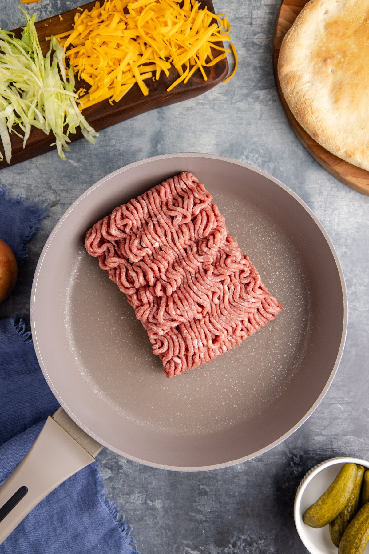 Ground beef added in a skillet to cook.