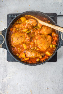 Chicken and vegetables cooking inside the skillet.
