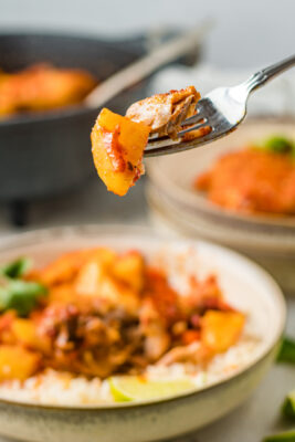 Closeup photo of a forkful of chicken and potato.