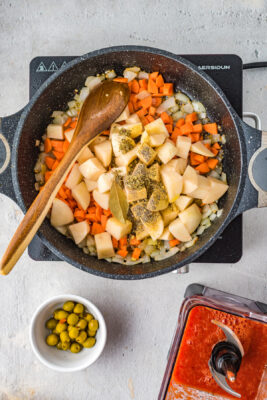 Potatoes, carrots and seasonings added to the skillet.