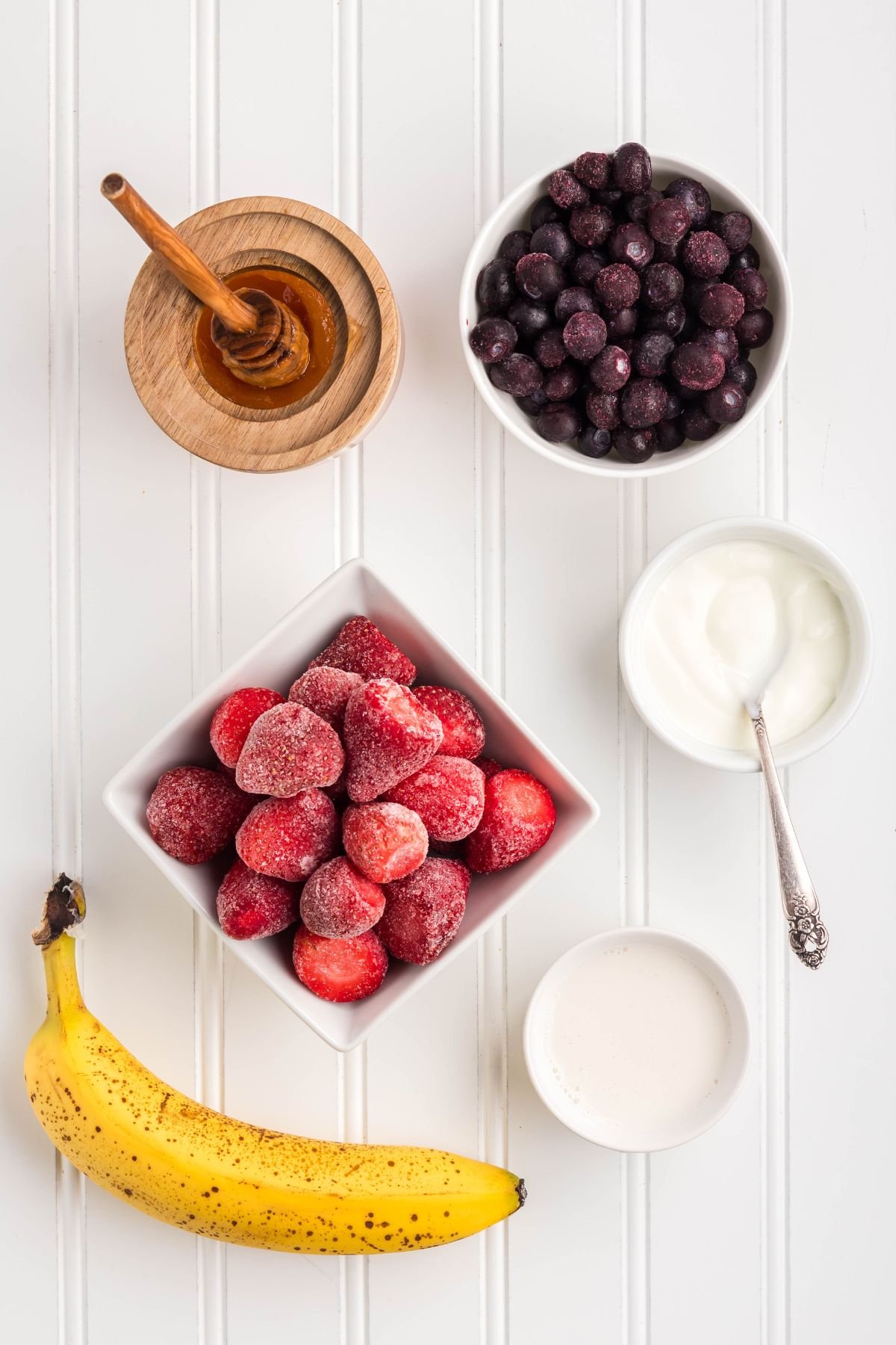 Ingredients for berry smoothie on a table.