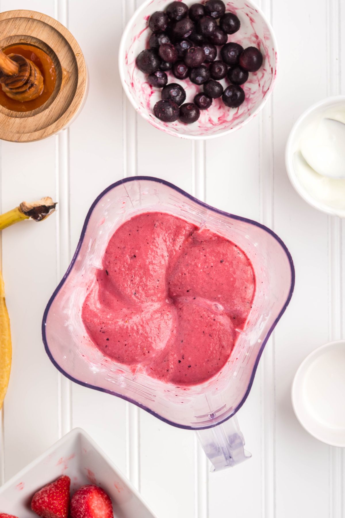 The fruit, yogurt, milk, and honey blended in a blender.