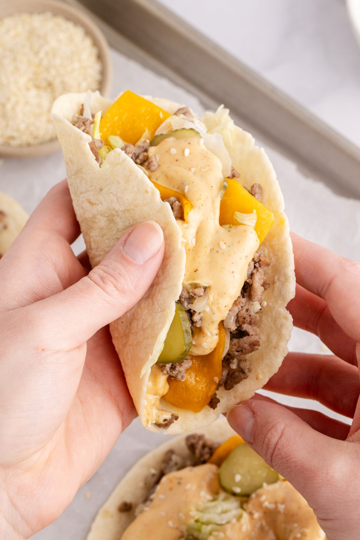Holding up a big mac taco in the air.