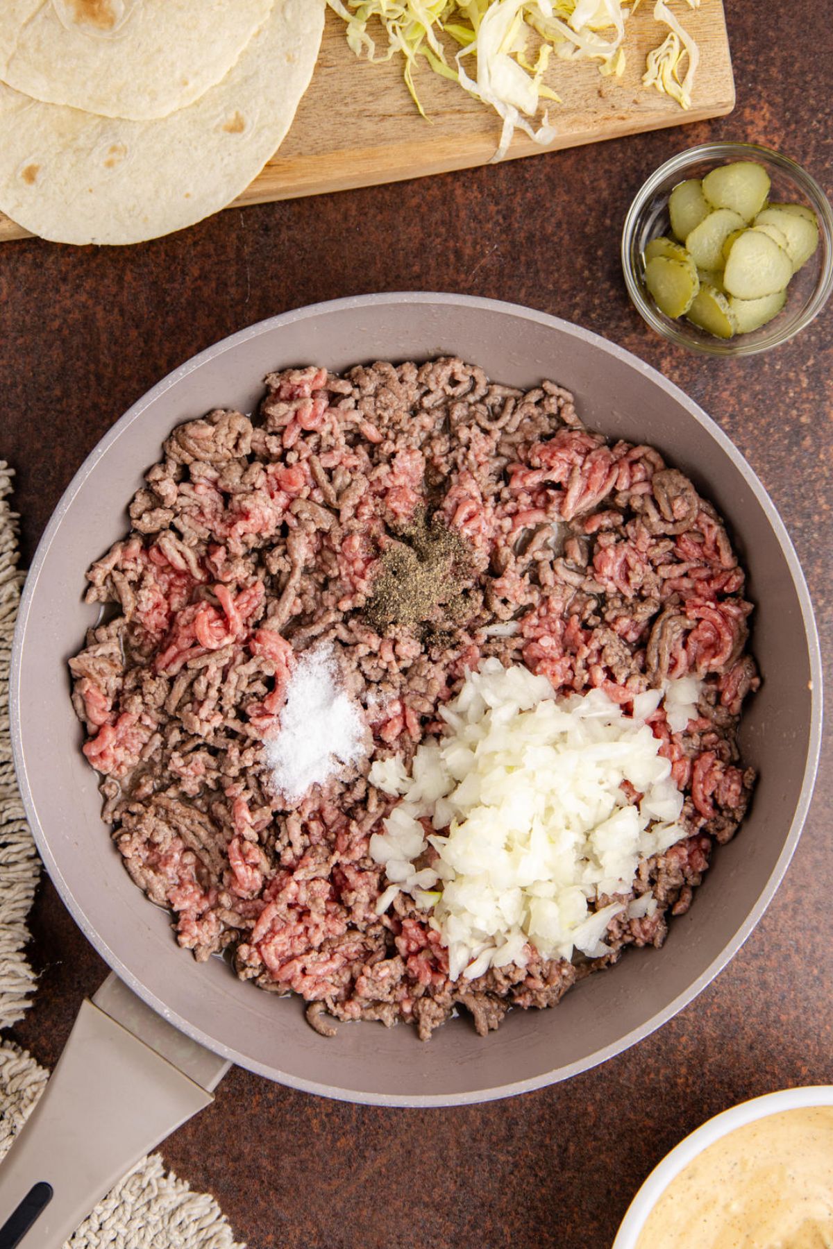 Ground beef and onions cooking in a skillet.