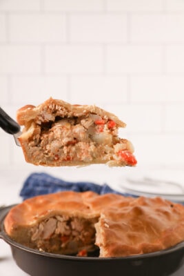 Closeup photo of a slice of pie held up by a pie knife.