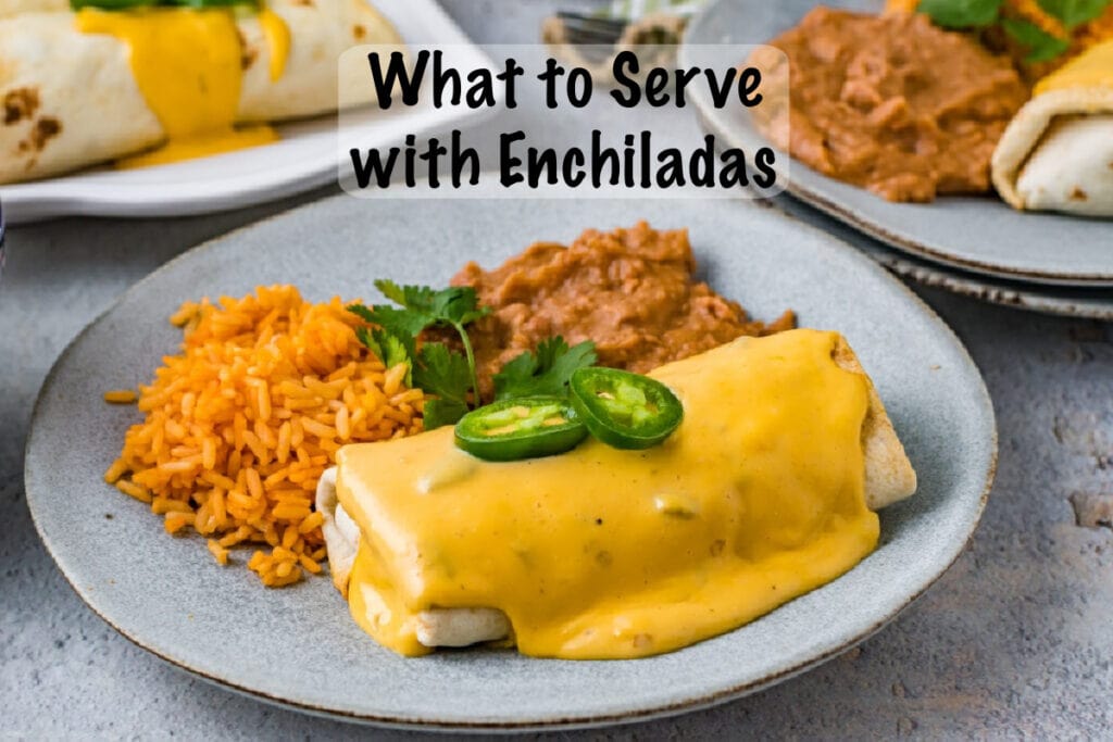 Enchilada side dishes of rice and refried beans next to enchilada garnished with jalapeno pepper slices and cilantro