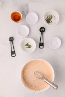 A bowl of buffalo ranch sauce in a bowl with a whisk.