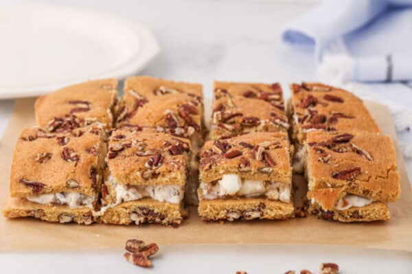 Side view of the butter pecan cookie ice cream sandwiches cut on a cutting board.