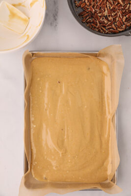 Dough is spread out into jelly roll pan to make butter pecan cookie ice cream sandwiches.