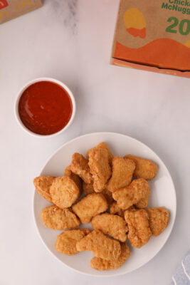 A plate of nuggets served up with McDonald's buffalo sauce on the table.