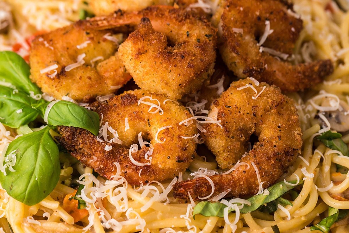 Shrimp on top of pasta.