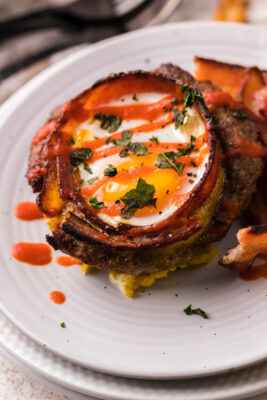 Keto Bacon egg cup drizzled with siracha in a zigzag pattern.