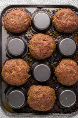 Bacon removed from muffin tin. Sausage placed at the bottom of the muffin tin to create a bowl shape with the sausage.