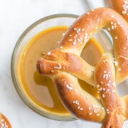 Honey mustard dip with a pretzel being dipped.