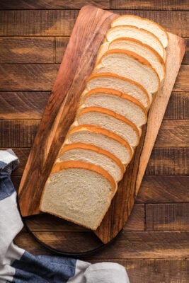 Slices of bread laid out on a wooden cutting board.