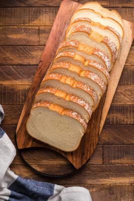 Thick slices of bread placed on a wooden cutting board.
