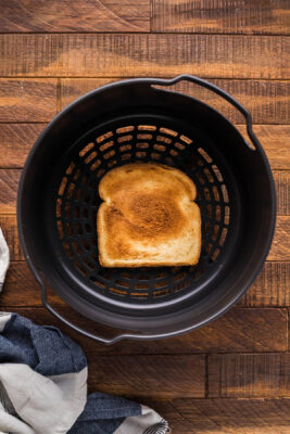 Toast placed inside an air fryer basket.