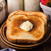 Two pieces of air fryer toast on plate with butter.