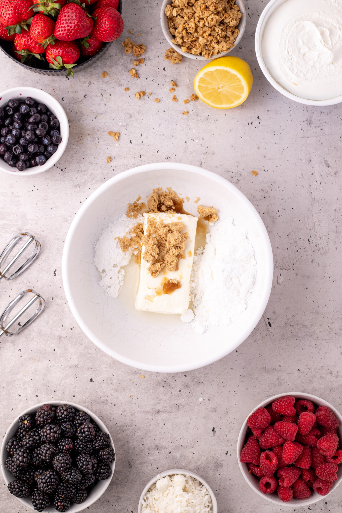 Cream cheese, brown sugar, powdered sugar, and vanilla in a white bowl.