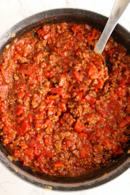 Tomato sauce and ground meat mixture in a skillet.
