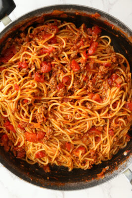 Spaghetti noodles and sauce mixed together in a skillet.