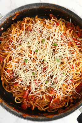Prepared spaghetti topped with parmesan cheese and parsley.