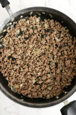 Cooked ground beef and onions in a skillet.