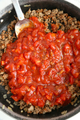 Tomato sauce added to the skillet with the cooked ground meat.