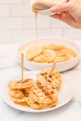 Pouring maple mustard syrup onto Fried chicken and waffles.
