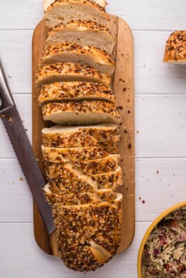 Overhead photo of a baguette sliced on a cutting board.