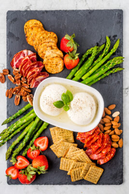 Ingredients placed on a board surrounding the Burrata cheese.