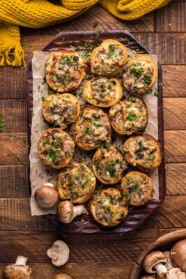 Wooden tray with mushroom appetizers toasts ready to eat.