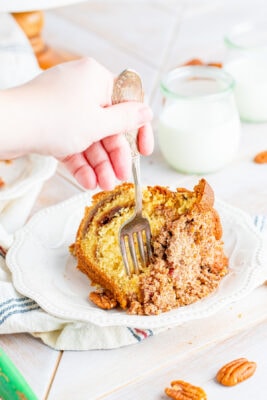 a slice of cake on a white plate with a fork in it