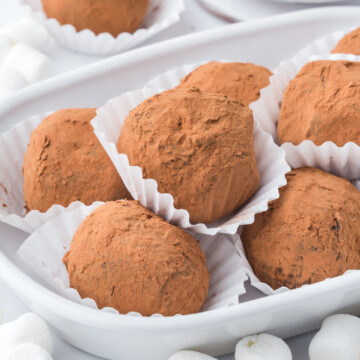 A pile of Hot Chocolate Truffles in paper cups on a serving plate.
