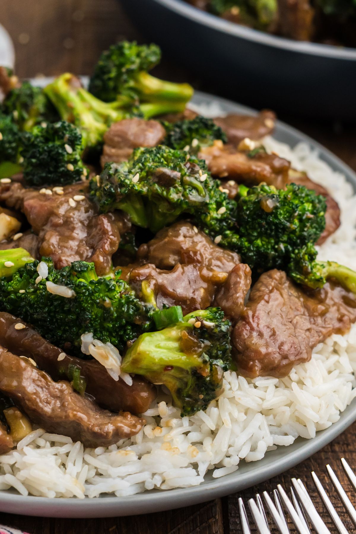 A plate of beef with broccoli over white rice.