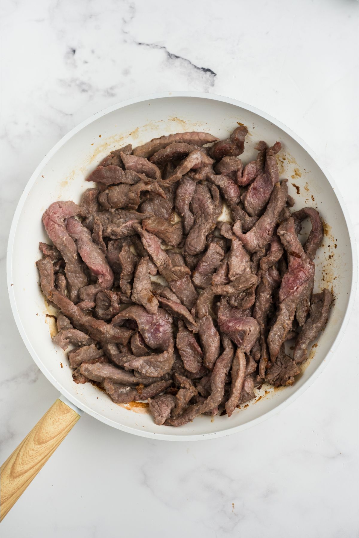 Steak cooking in a skillet.