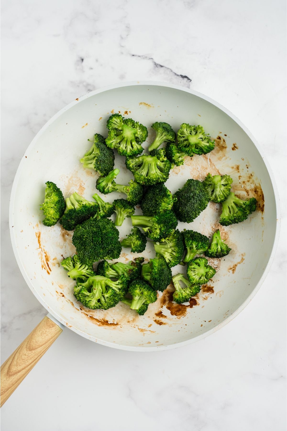 Broccoli added in the same skillet with a splash of water.