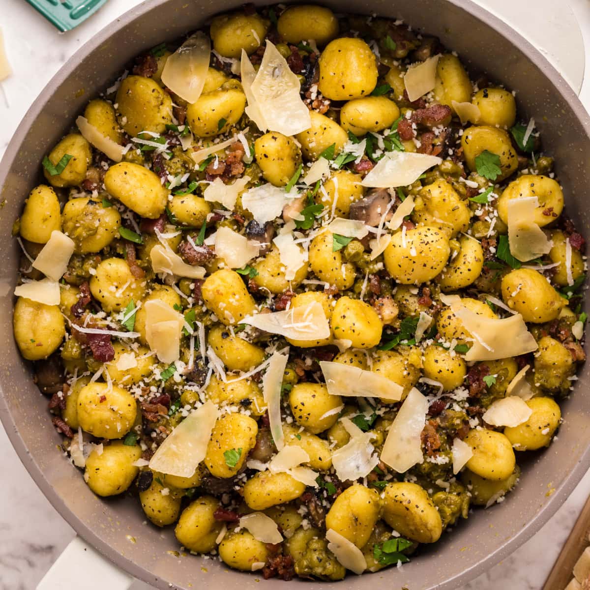 Pan full of Gnocchi Carbonara with shaved parmesan cheese on top 