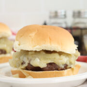 McDonald's grilled onion cheddar burger on plate.
