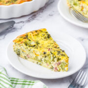 A slice of crustless quiche keto on a white plate.