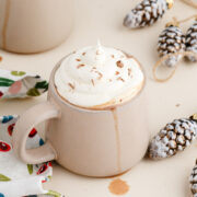 A mug of Mcdonald's copycat peppermint mocha on the table with pinecones and a linen towel.