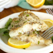 Baked catfish no breading on a plate split in half to show the cooked inside.
