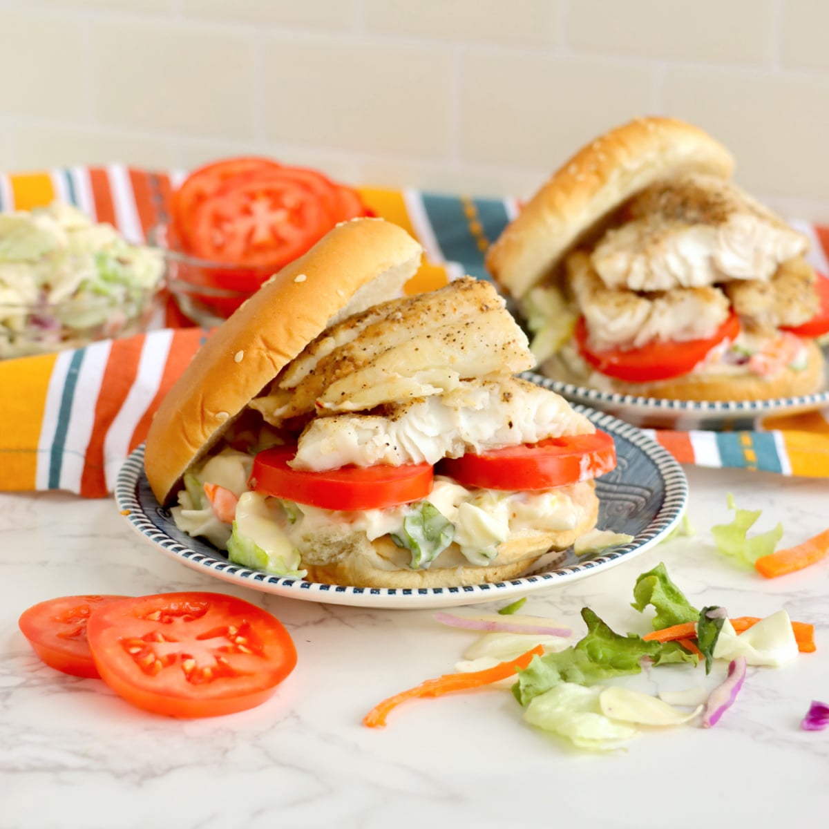 2 Catfish Sandwiches with tomatoes on a plate 