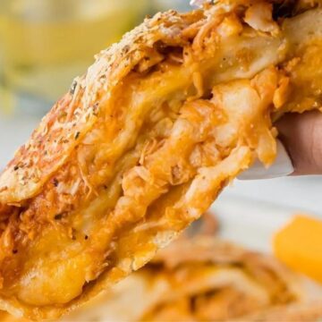 A slice of stromboli held in the air.