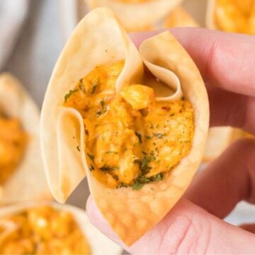 A Buffalo Chicken Wonton Cup held in the air.