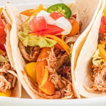 Three soft tacos on plate.