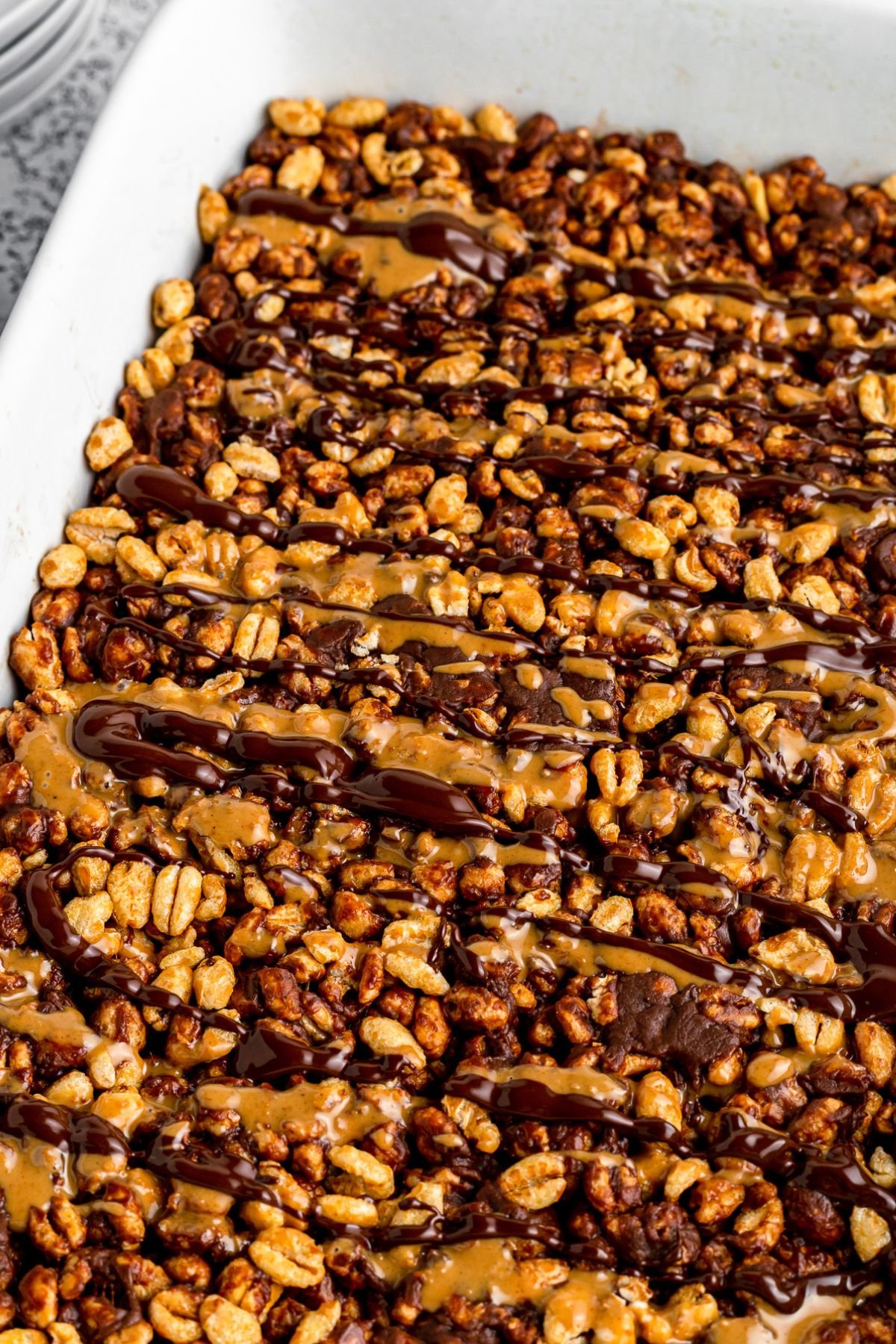Peanut butter and chocolate drizzle over top of the cereal mixture.