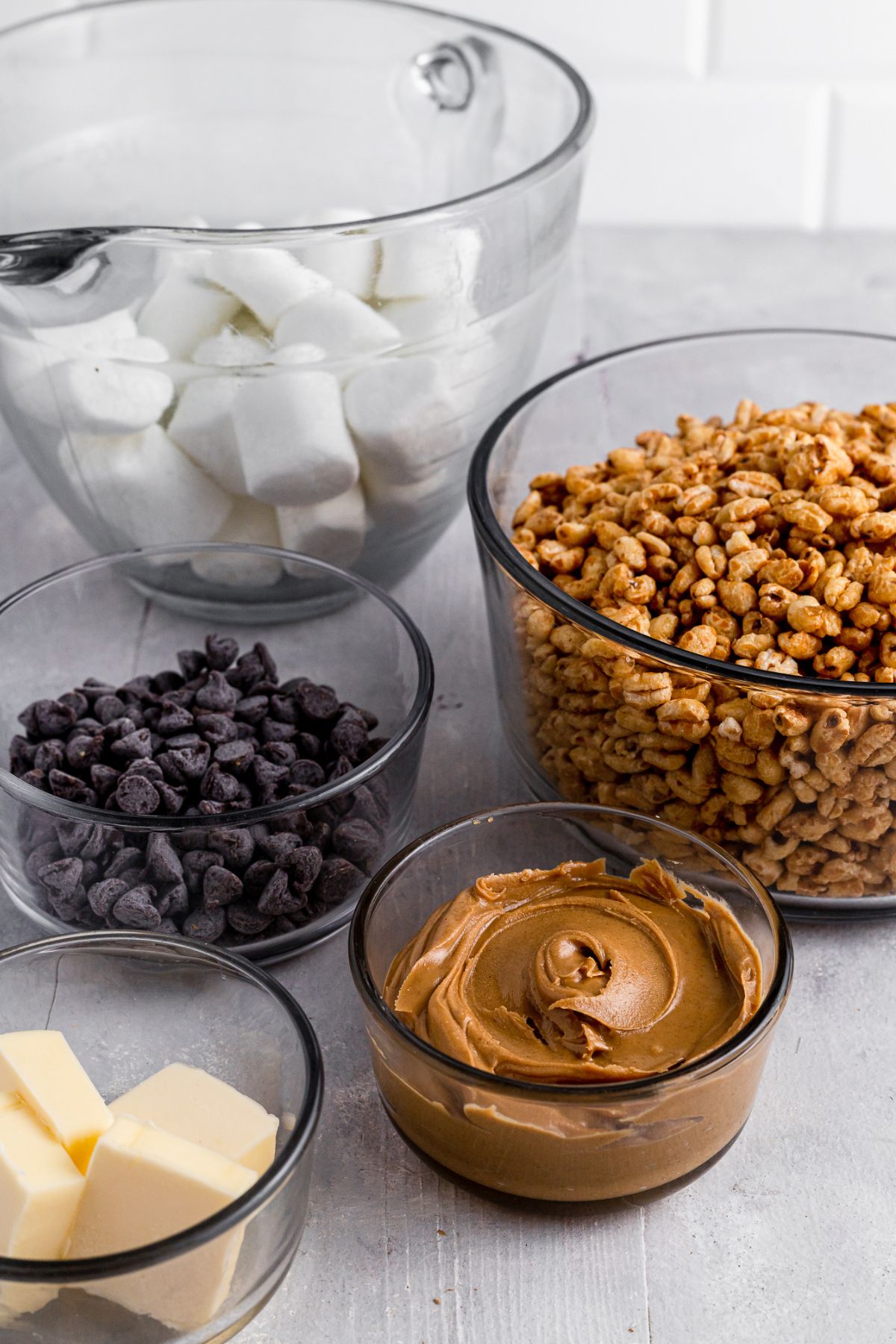 Ingredients for golden crisp marshmallow cereal bars in bowls on a table.