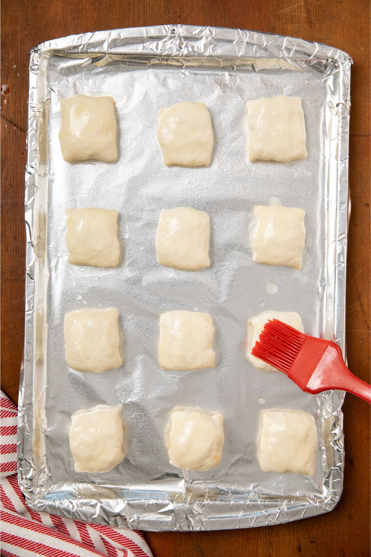 Melted butter brushed over each square on a baking sheet.