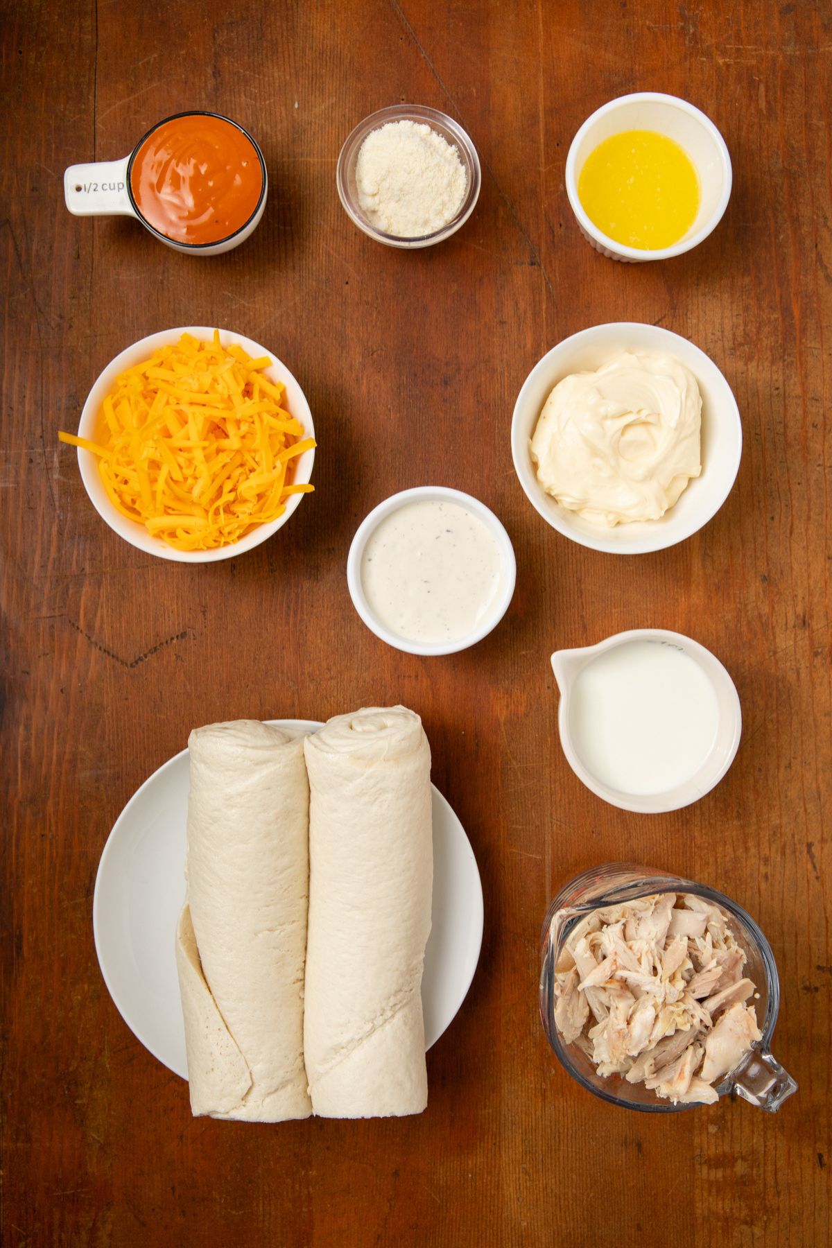 Ingredients for buffalo chicken bites in bowls on a table.